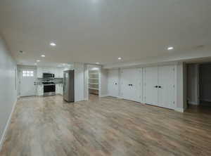 Unfurnished living room with a textured ceiling and light hardwood / wood-style flooring