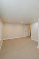 Carpeted spare room featuring a textured ceiling