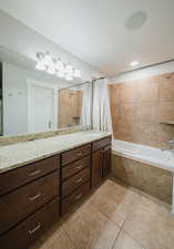 Bathroom featuring tile patterned flooring, vanity, and shower / bath combination with curtain