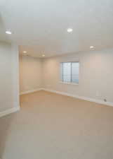 Carpeted empty room with a textured ceiling