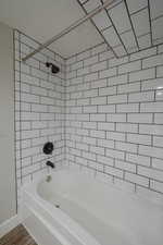 Bathroom featuring hardwood / wood-style flooring and tiled shower / bath