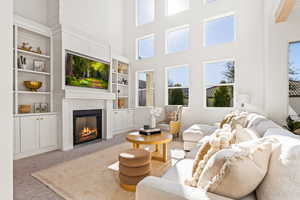 Carpeted living room with a towering ceiling