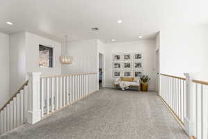 Sitting room featuring carpet flooring and a notable chandelier