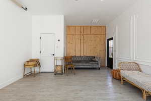 Living area with light hardwood / wood-style flooring, a textured ceiling, and wood walls