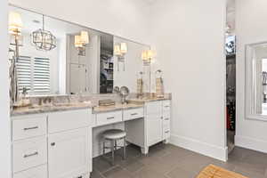 Bathroom featuring vanity, tile patterned flooring, and washer / dryer