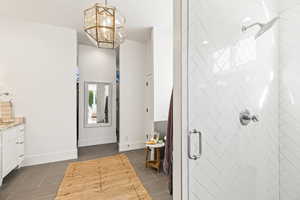 Interior space featuring vanity, an inviting chandelier, and walk in shower