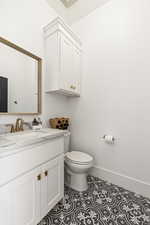 Bathroom featuring tile patterned floors, toilet, and vanity