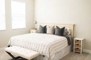 Bedroom featuring light carpet