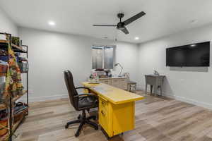 Home office with ceiling fan and light wood-type flooring