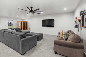 Living room with ceiling fan and carpet