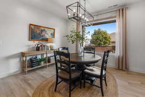 Dining room featuring an inviting chandelier and light hardwood / wood-style flooring