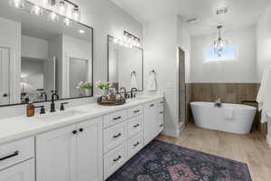 Bathroom featuring vanity, wood-type flooring, and a tub