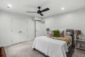 Bedroom with ceiling fan, carpet flooring, and a closet