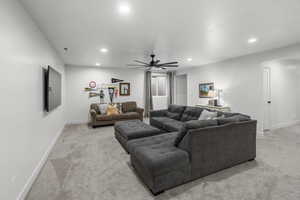 Carpeted living room with ceiling fan