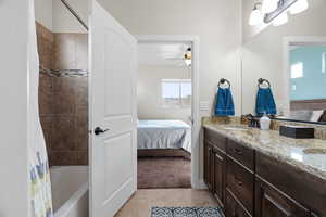 Bathroom featuring tile patterned flooring, vanity, shower / tub combo, and ceiling fan