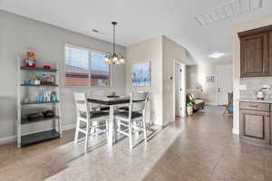 Tiled dining room featuring an inviting chandelier