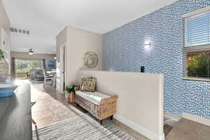 Interior space featuring ceiling fan and tile walls