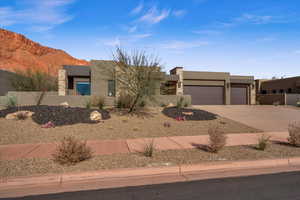 Pueblo-style house with a garage and a mountain view