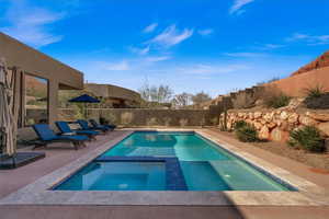 View of swimming pool featuring a patio area and an in ground hot tub