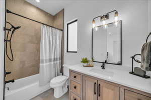 Full bathroom featuring vanity, shower / tub combo, and toilet