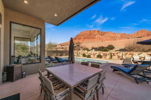 View of patio with a swimming pool with hot tub and a mountain view