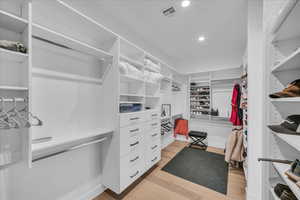 Spacious closet with light hardwood / wood-style floors