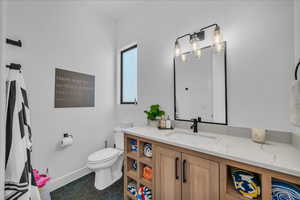 Bathroom featuring vanity, toilet, and tile patterned flooring