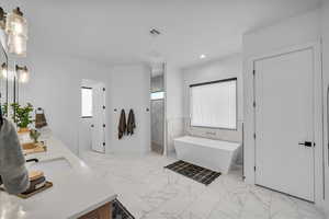 Bathroom with vanity, independent shower and bath, and tile walls