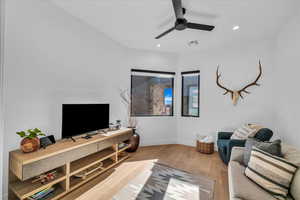 Living room with ceiling fan and light wood-type flooring