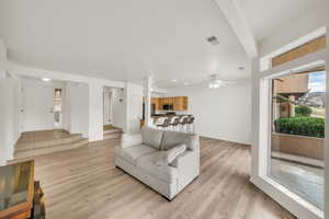 Living room with ceiling fan and light wood-type flooring