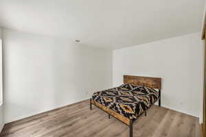 Bedroom with light hardwood / wood-style flooring and a textured ceiling