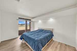 Bedroom with access to exterior and light wood-type flooring