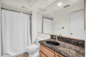 Bathroom featuring vanity, tile patterned floors, and toilet