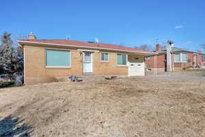 Rear view of property with a garage and a lawn