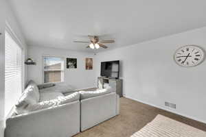 Living room featuring carpet and ceiling fan