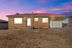 Single story home featuring a garage and a lawn