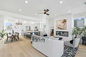 Living room with sink, light hardwood / wood-style flooring, and ceiling fan