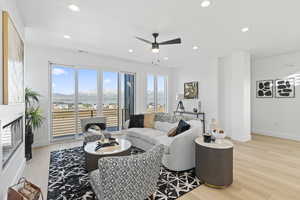 Living room with ceiling fan, a mountain view, and light wood-type flooring