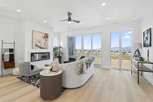 Living room featuring a mountain view, ceiling fan, and light wood-type flooring