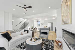 Living room with ceiling fan, beverage cooler, and light hardwood / wood-style floors