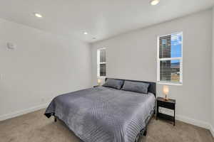 Bedroom featuring light carpet