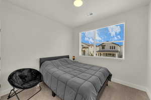 Bedroom featuring light carpet