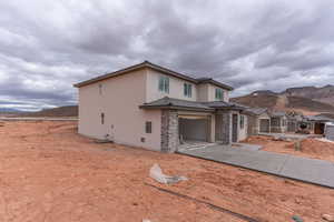 View of front of home with a mountain view and a garage