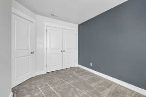 Unfurnished bedroom featuring a closet and carpet