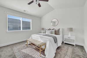 Carpeted bedroom with ceiling fan and vaulted ceiling