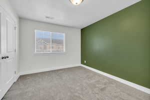 Carpeted empty room with a textured ceiling