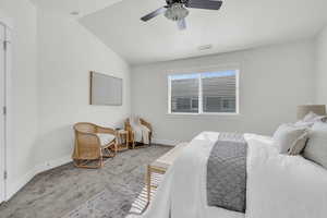 Carpeted bedroom with vaulted ceiling and ceiling fan