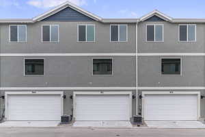 Back of house featuring a garage and central AC