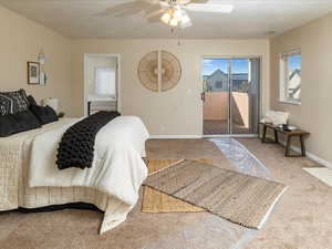 Carpeted bedroom with ceiling fan, access to exterior, and a textured ceiling