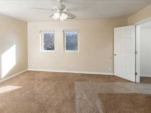 Carpeted empty room featuring ceiling fan